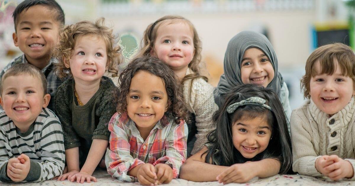 Kids of different ethnicities smiling together, representing diversity in online Quran learning