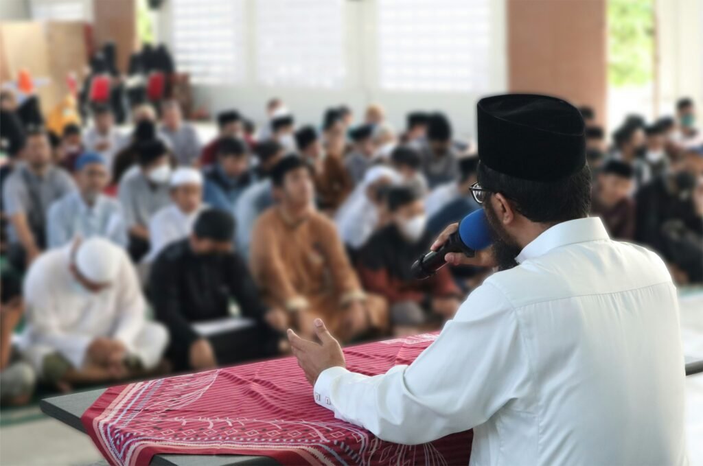 Islamic teacher addressing students in a madrasa classroom during Quran lesson showing traditional in-person Quran education