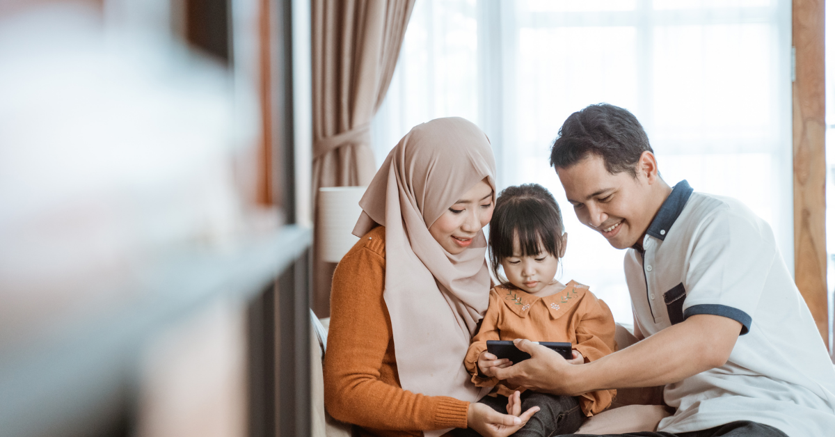 Parents helping their child stay focused during online Quran classes at home